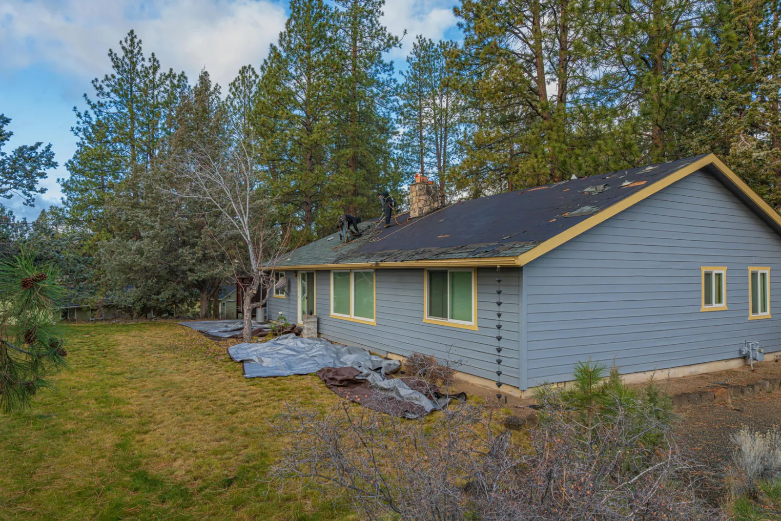 Finished composition roof on the blue single-story home