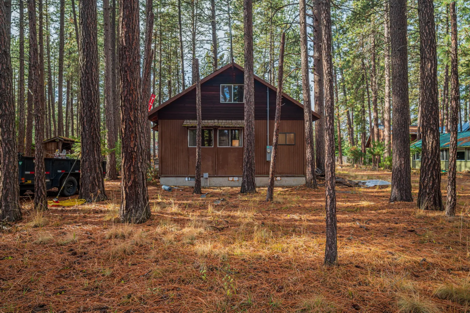 Wood-sided home with a new roof in a Central Oregon pine forest