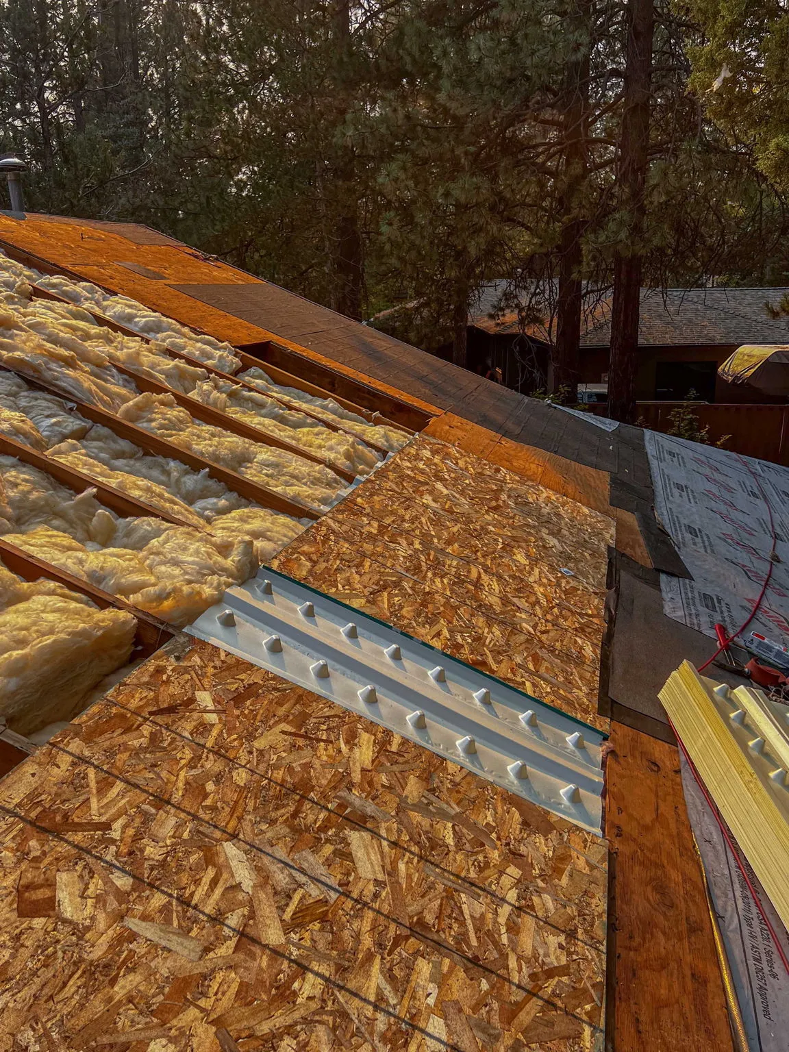New sheathing panels going down over the insulated roof structure