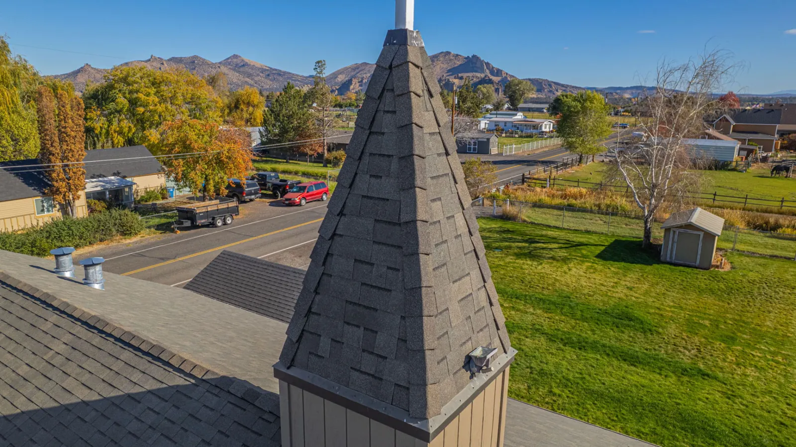 Close aerial of the shingled steeple above the roofline