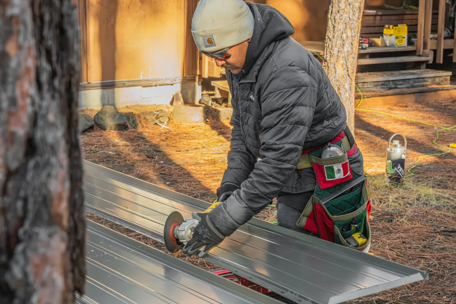 Cutting a metal panel with a grinder at the staging area