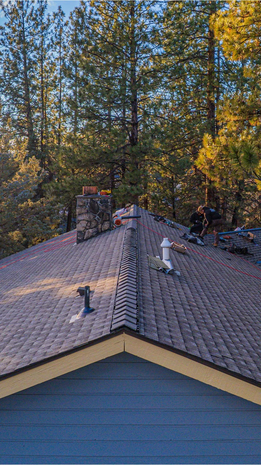 Crew finishing ridge work in late-afternoon light