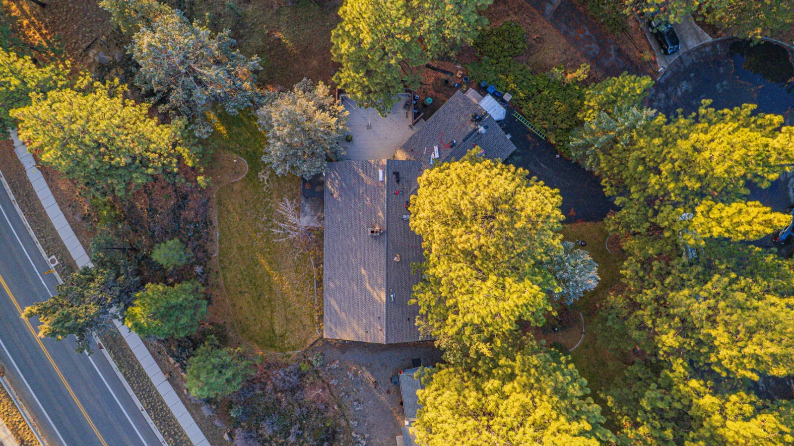Aerial view of pine-lined Bend, Oregon rooftops photographed on a Spey Roofing job