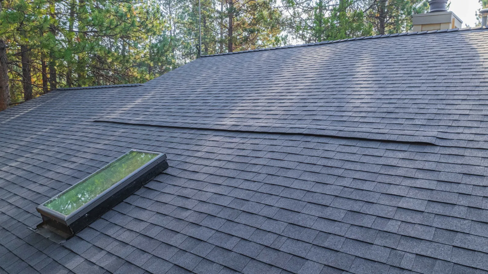 Close view of skylight flashing in the finished shingle roof
