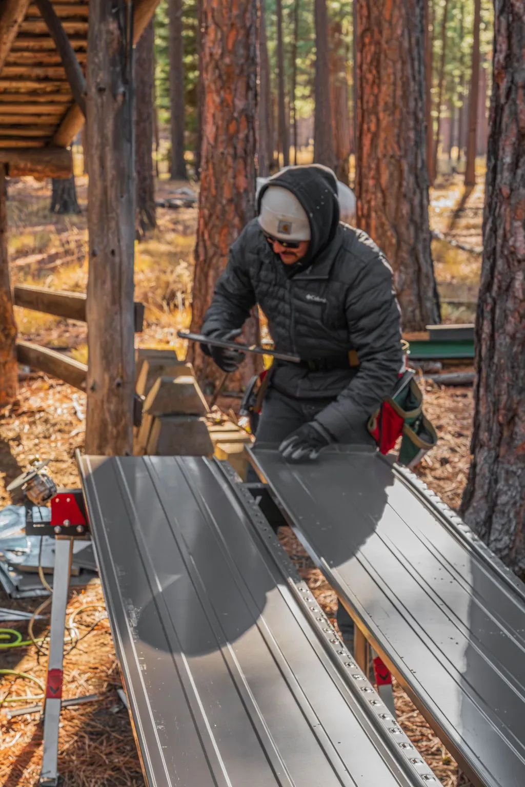 Spey Roofing crew member cutting a metal roof panel on site