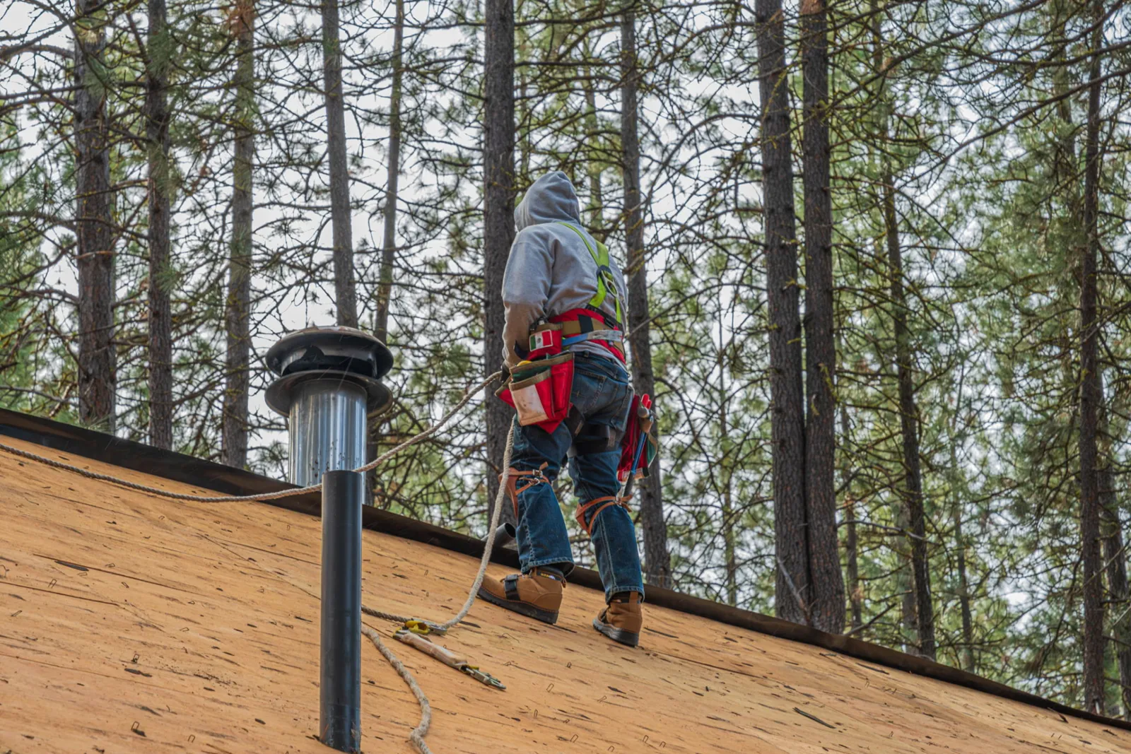 Crew member fastening decking on the steep roof plane